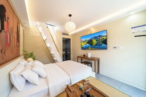 Una camera d'albergo con un letto, una scrivania, una televisione e un quadro appeso al muro.