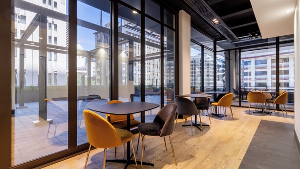 A modern interior with large windows, wooden flooring, and contemporary furniture.