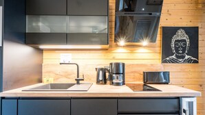 Een moderne keuken met een roestvrijstalen spoelbak, een koffiezetapparaat en een broodrooster.
