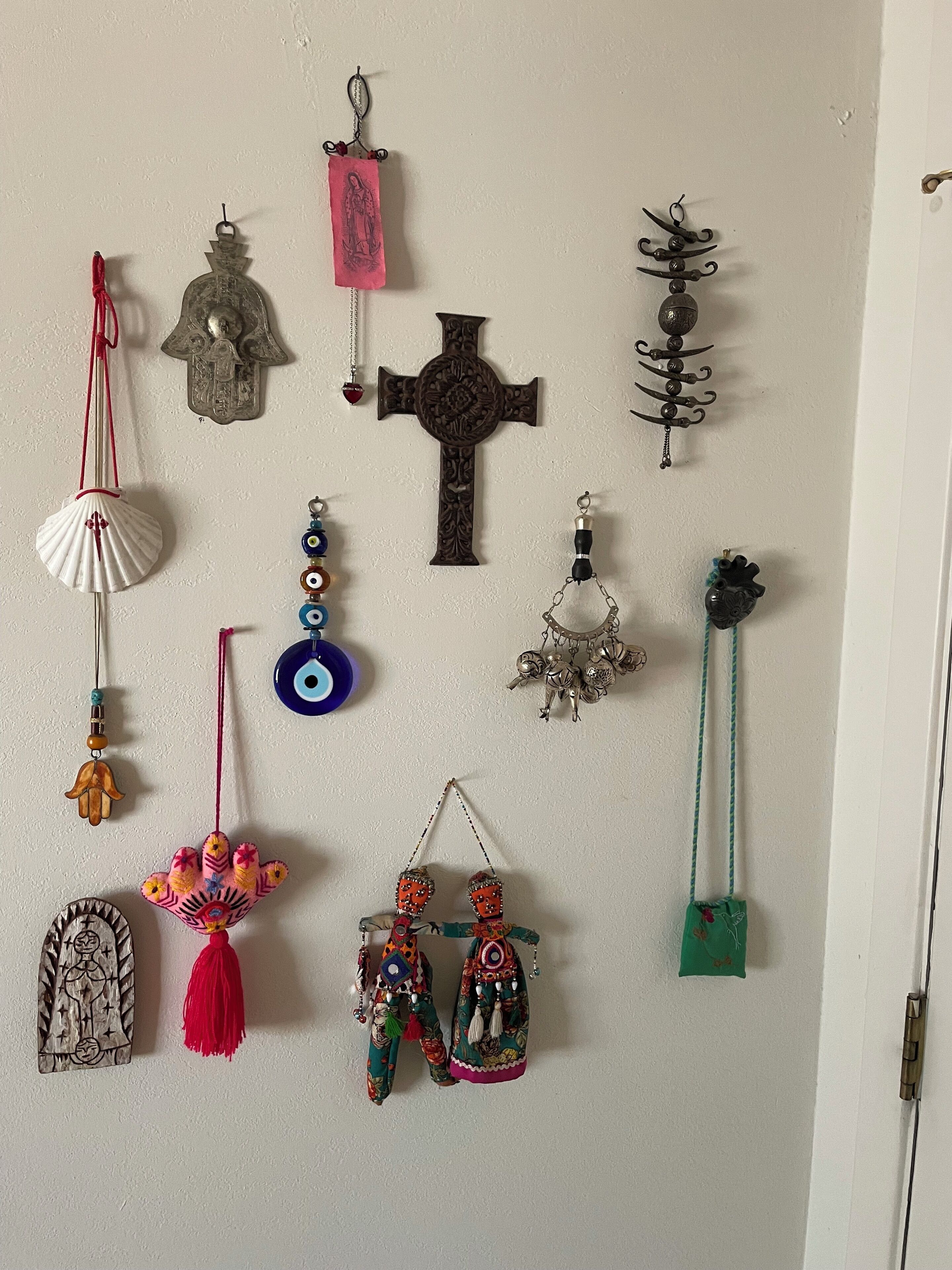 A variety of wall hangings including crosses, a hand, and decorative items.