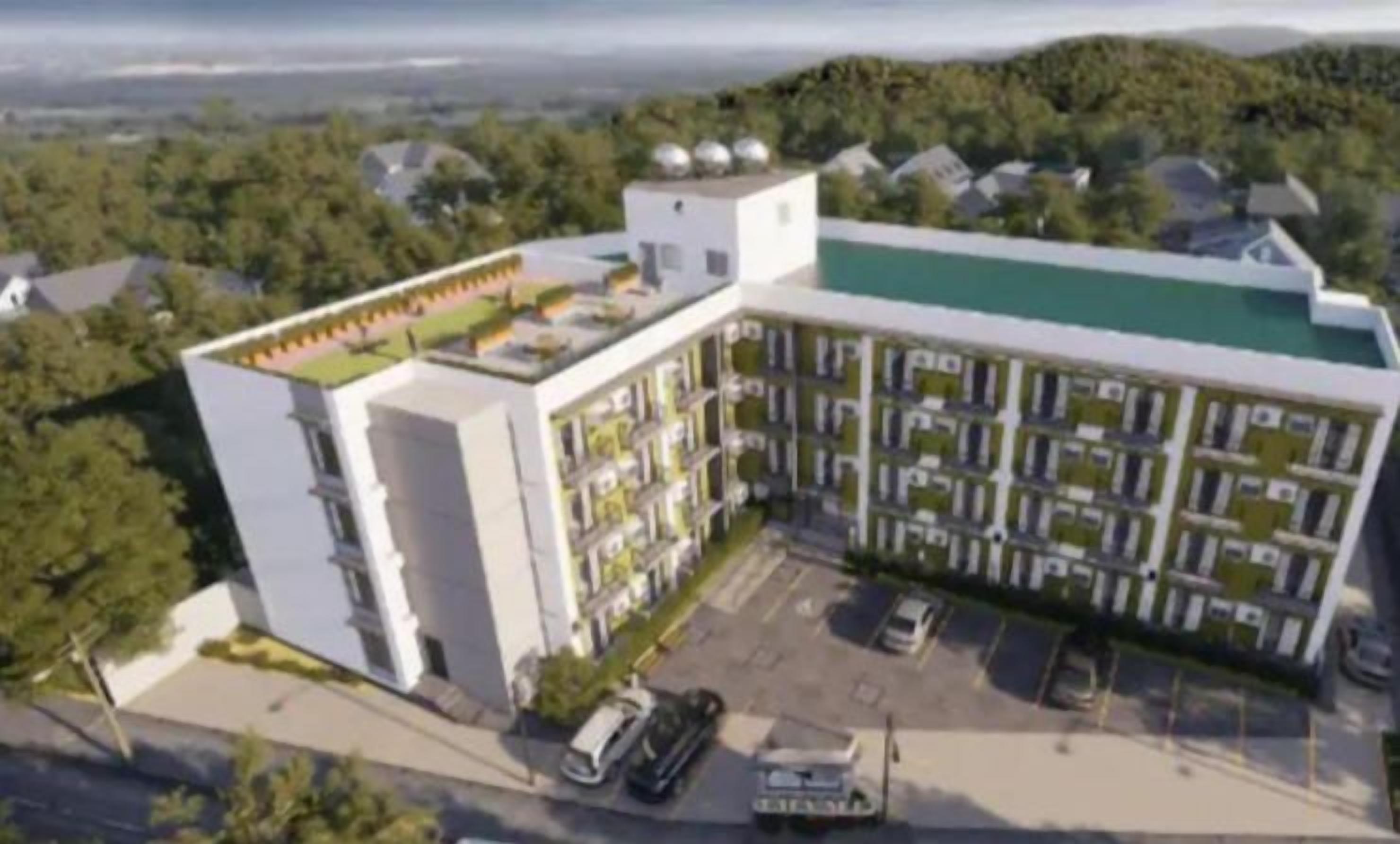 Een modern meerlaags gebouw met een plat dak, omgeven door groen en andere woongebouwen.