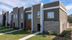 A modern apartment building with a uniform facade, multiple windows, and a well-maintained lawn. - Charming Getaway Near Disney (Davenport)
