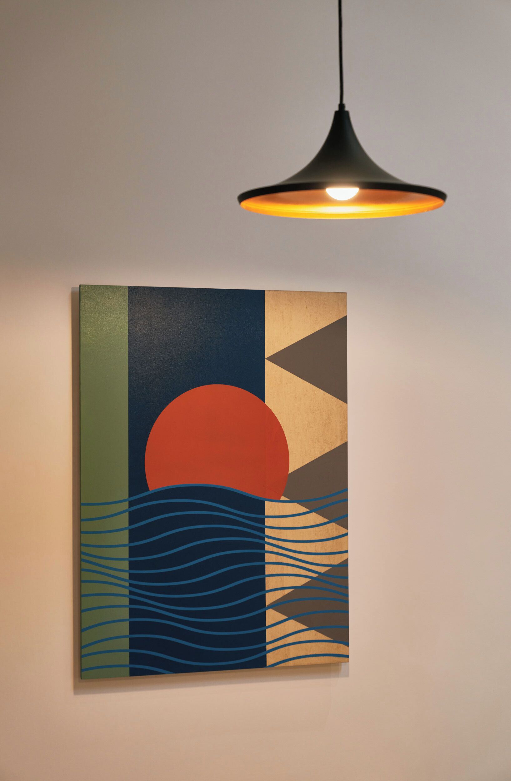 A wall-mounted artwork with geometric shapes and a sunset design.
