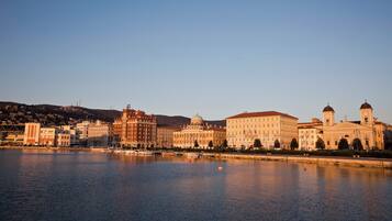 A waterfront cityscape with historic buildings, a river, and a clear sky.