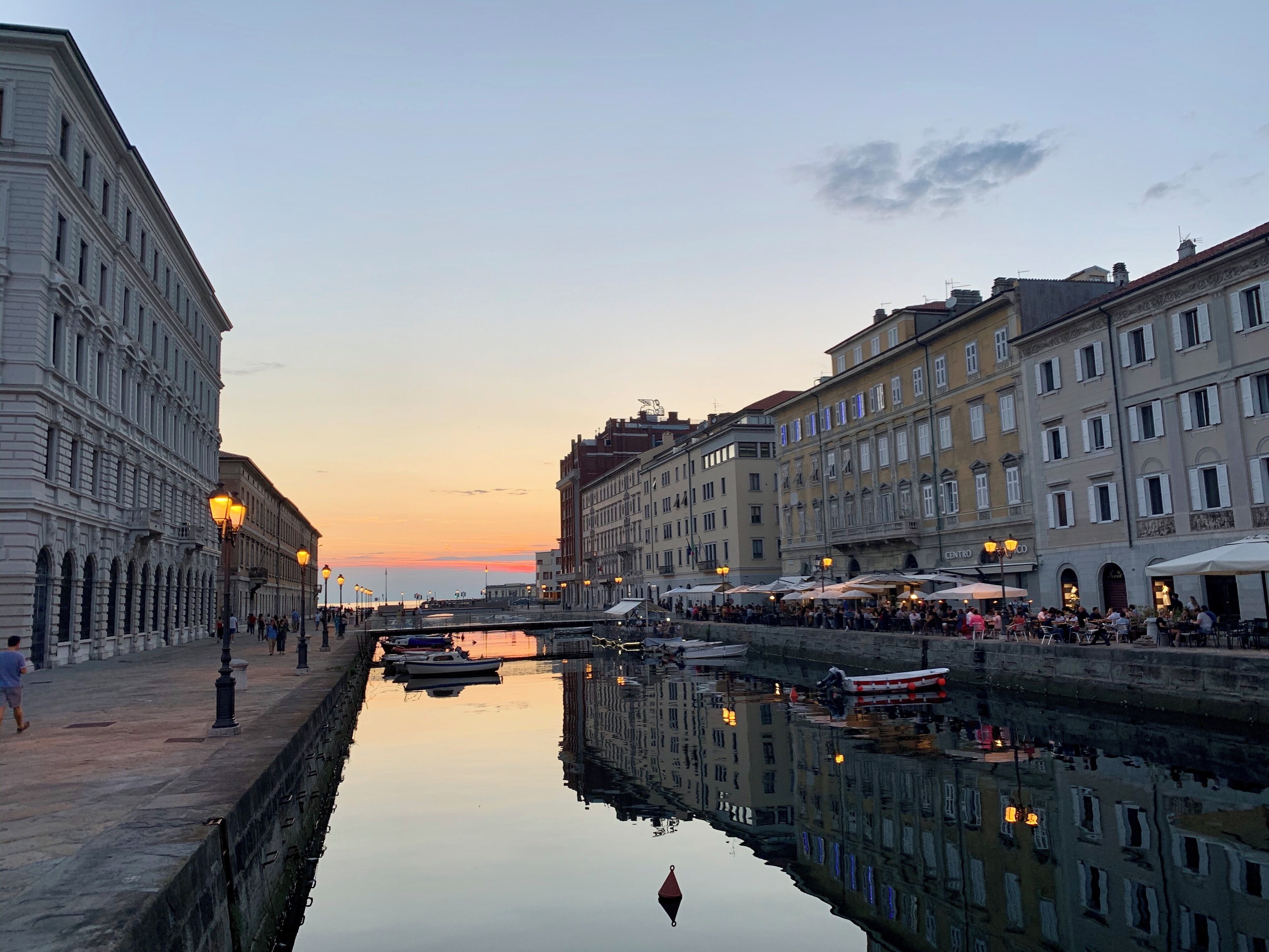 A canal with boats, a bridge, and buildings along the water.