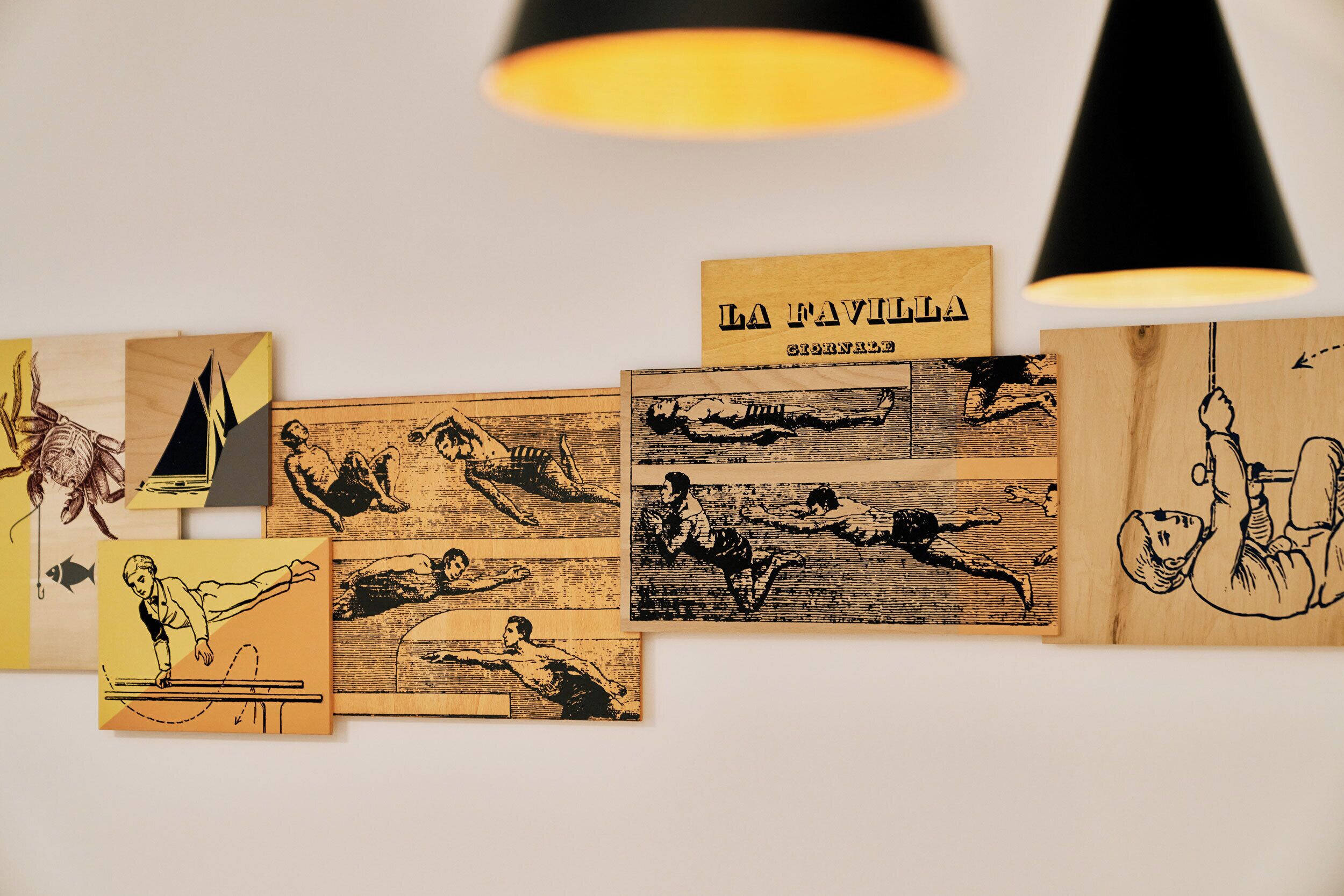 A wall with various black and white illustrations and a sign that reads "LA NAVILLA".
