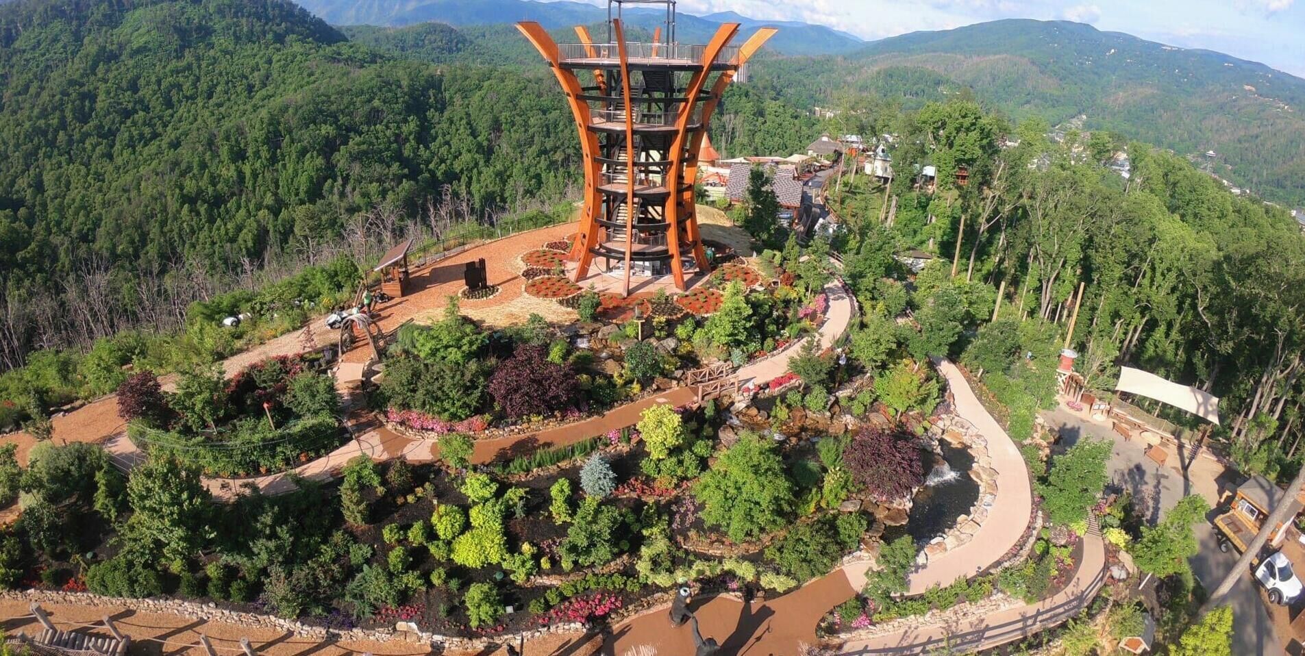 Une structure à plusieurs niveaux, dotée d’un escalier en colimaçon, entourée de jardins en terrasses et agrémentée d’un petit élément décoratif aquatique.