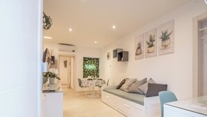 Una sala moderna con un sofá, una mesa de comedor y una zona de cocina.
