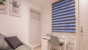 Un dormitorio con cama, escritorio y silla.