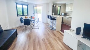 A modern apartment with a dining area, kitchen, and living space. - Marina Secret in Vilamoura (Loulé)