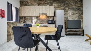 Une cuisine moderne dotée d’un îlot central, d’appareils électroménagers intégrés et d’un coin repas avec des chaises.