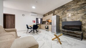 Un salon moderne avec un canapé, une table basse en verre et un meuble pour la télévision.