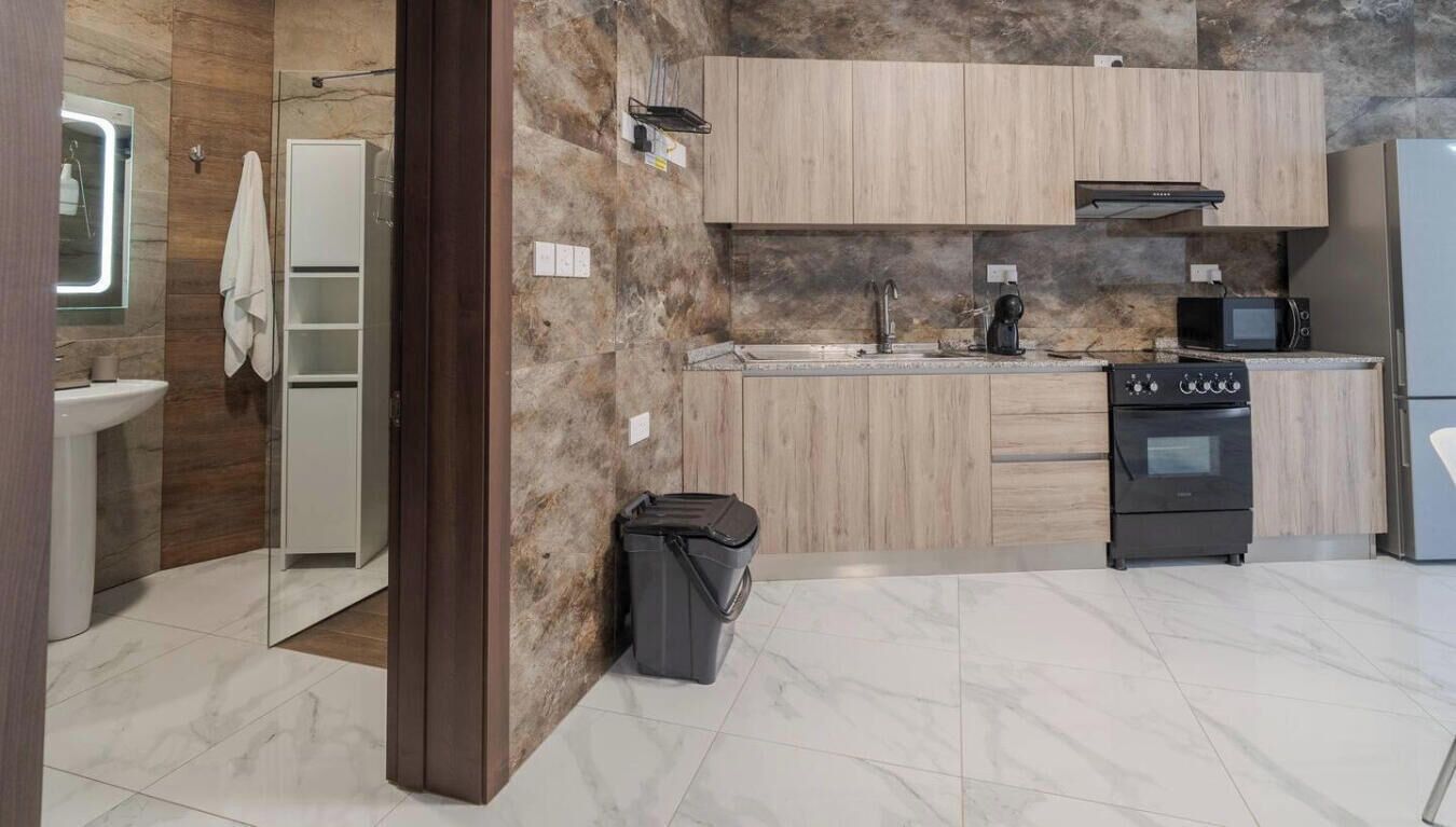 A modern kitchen with a built-in oven, microwave, and sink.