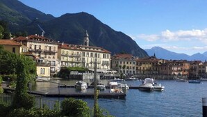 A waterfront area with buildings, a dock, and boats. - A Hidden Gem in Menaggio – Elegant Apartment with Terrace & Lake Views (Menaggio)