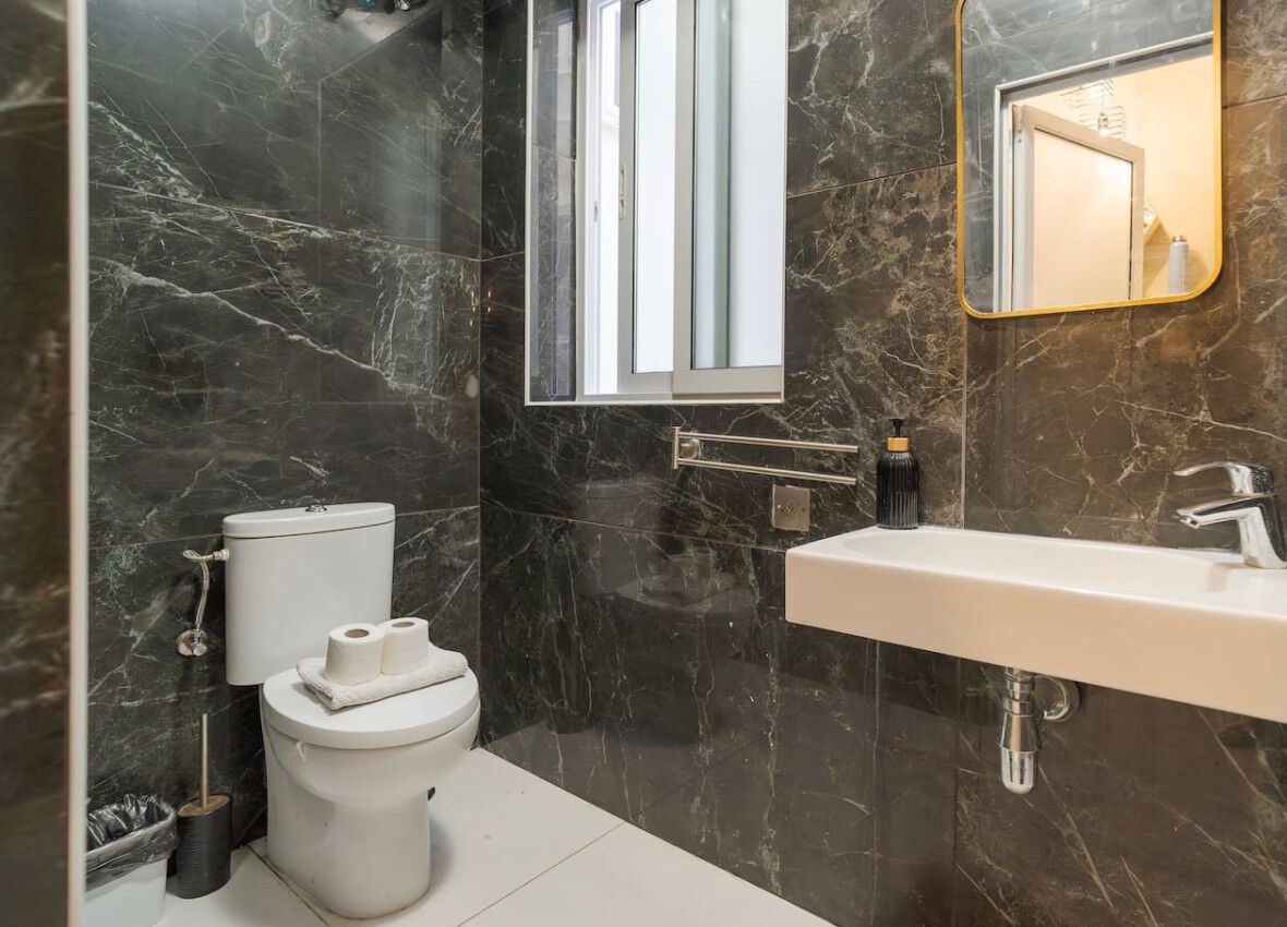 Un baño con inodoro, lavabo y espejo.