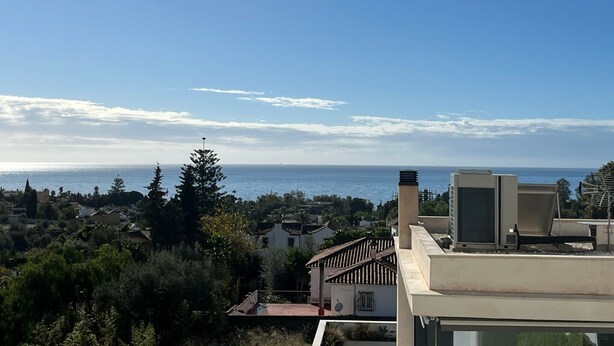 A coastal residential area with a clear view of the sea, a modern building with a flat roof, and a traditional house with a tiled roof. - Bright 'Luminoso Marbella' Apartment with Sea Views, Wi-Fi and Air Conditioning (Marbella)