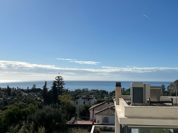 A coastal residential area with a clear view of the sea, a modern building with a flat roof, and a traditional house with a tiled roof. - Bright 'Luminoso Marbella' Apartment with Sea Views, Wi-Fi and Air Conditioning (Marbella)