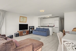 A modern living room with a sofa, a television, and a small coffee table.