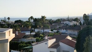 A coastal residential area with houses, palm trees, and a view of the sea. - Bright 'Luminoso Marbella' Apartment with Sea Views, Wi-Fi and Air Conditioning (Marbella)