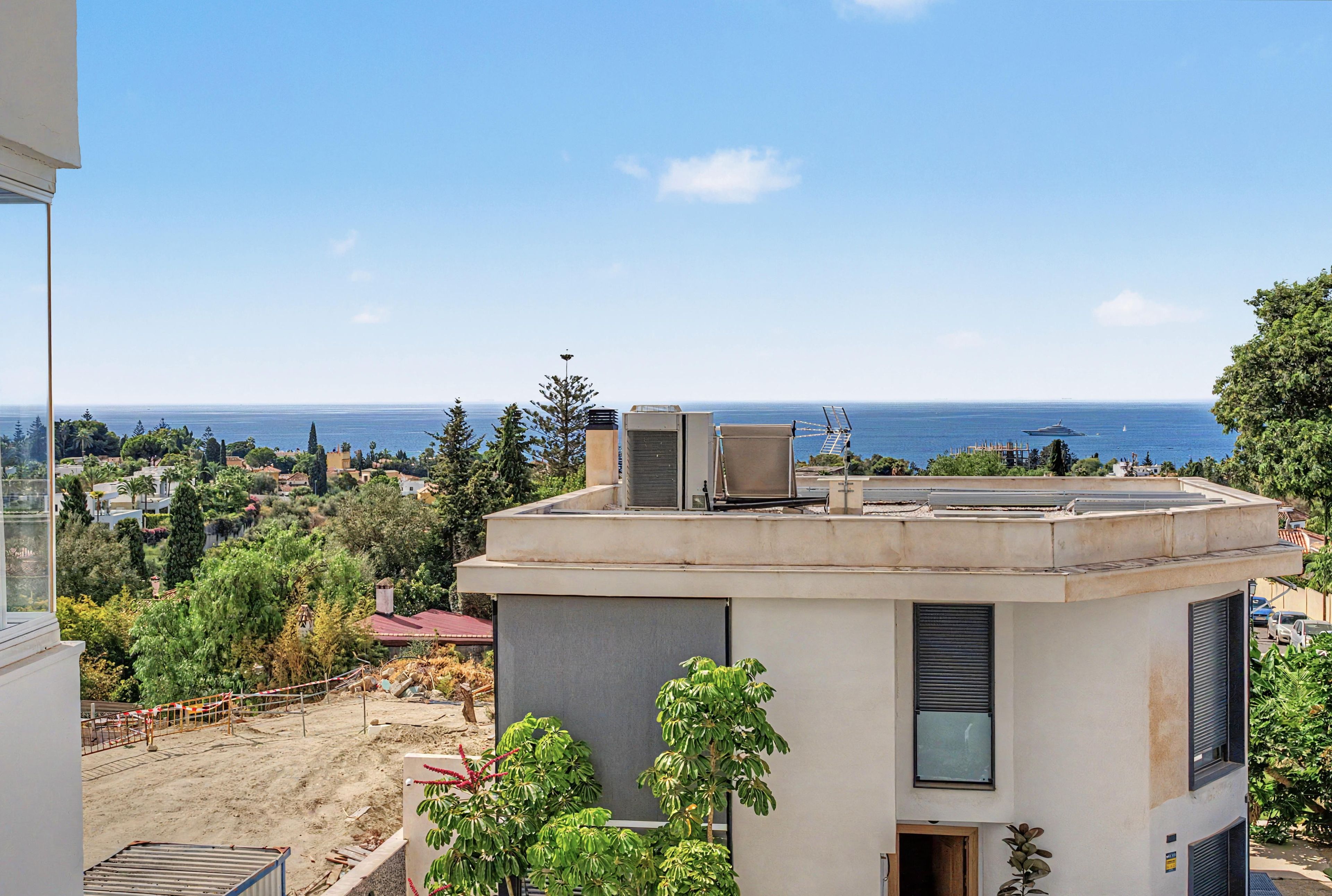 Un bâtiment moderne doté d’une terrasse sur le toit offrant une vue panoramique sur la côte.