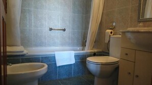 A bathroom with a bathtub, two toilets, a bidet, and a sink. - Hotel Luz del Guadiana (Ayamonte)