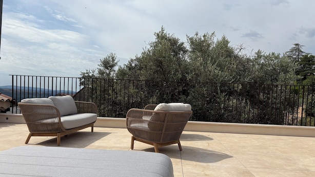 A balcony with two wicker sofas and a large grey lounge chair, overlooking a mountainous landscape with dense trees and a clear sky. - Roof top MARZE (Aubenas)