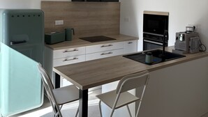 A modern kitchen with a central island, a built-in oven, a microwave, and a coffee machine. - Roof top MARZE (Aubenas)