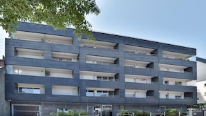 A multi-story residential building with balconies, a gated entrance, and a sign indicating the address. - Horizon Dinardais - Proche Plages (Dinard)