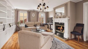 Una sala de estar con chimenea, un sofá, una mesa de centro y una estantería.