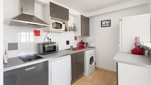 Una cocina compacta equipada con microondas, tostadora, lavaplatos y fregadero.