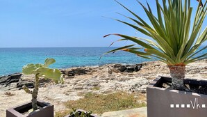 A coastal view with a rocky beach and a clear blue sky.