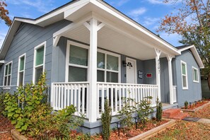 A single-story house with a porch, a 'Beach House' sign, and a 'No Trespassing' sign. - Perfect Two Bedrooms with Fenced Yard and Three Blocks to Beach (Myrtle Beach)