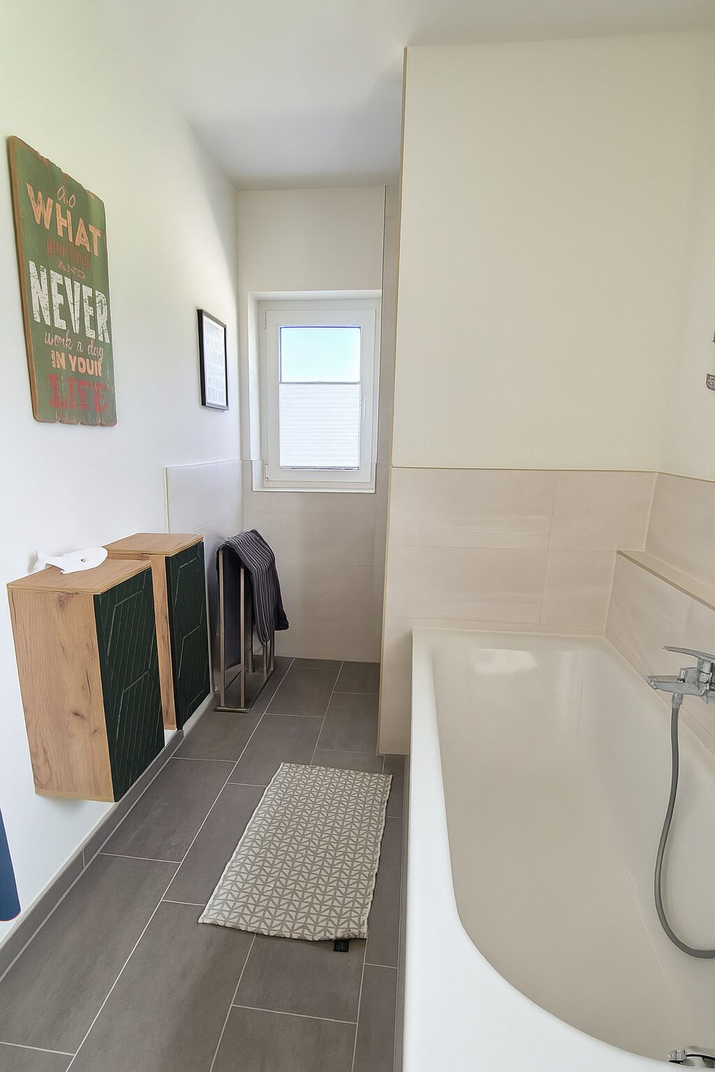 Ein modernes Badezimmer mit Badewanne, Dusche und Fenster.