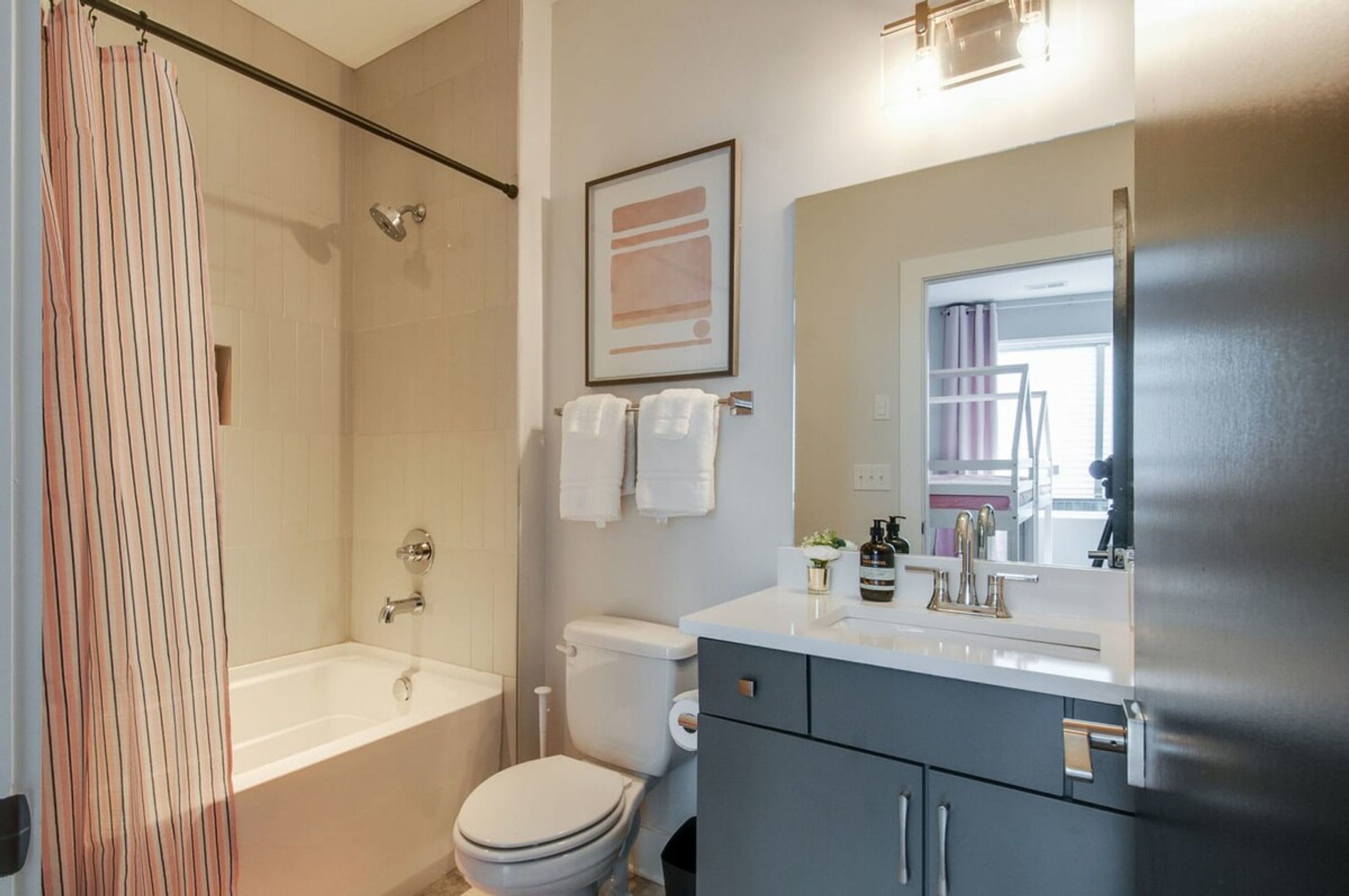 A modern bathroom with a bathtub, toilet, and sink.
