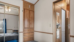 Un dormitorio con una cama grande, un armario de madera y un ventilador de techo.