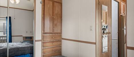 Un dormitorio con una cama grande, un armario de madera y un ventilador de techo.