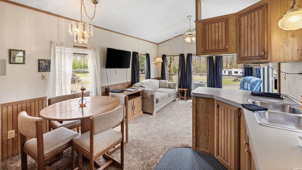 Un espacio habitable compacto con comedor, kitchenette y zona de estar.