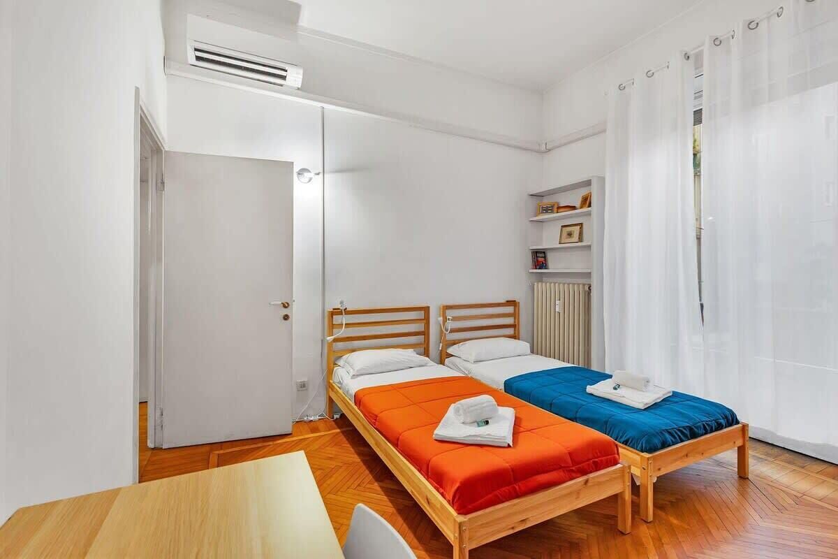 A room with two wooden beds, a wooden table, and a white radiator.