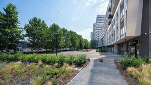 A pathway leading to a modern building with a landscaped garden area.