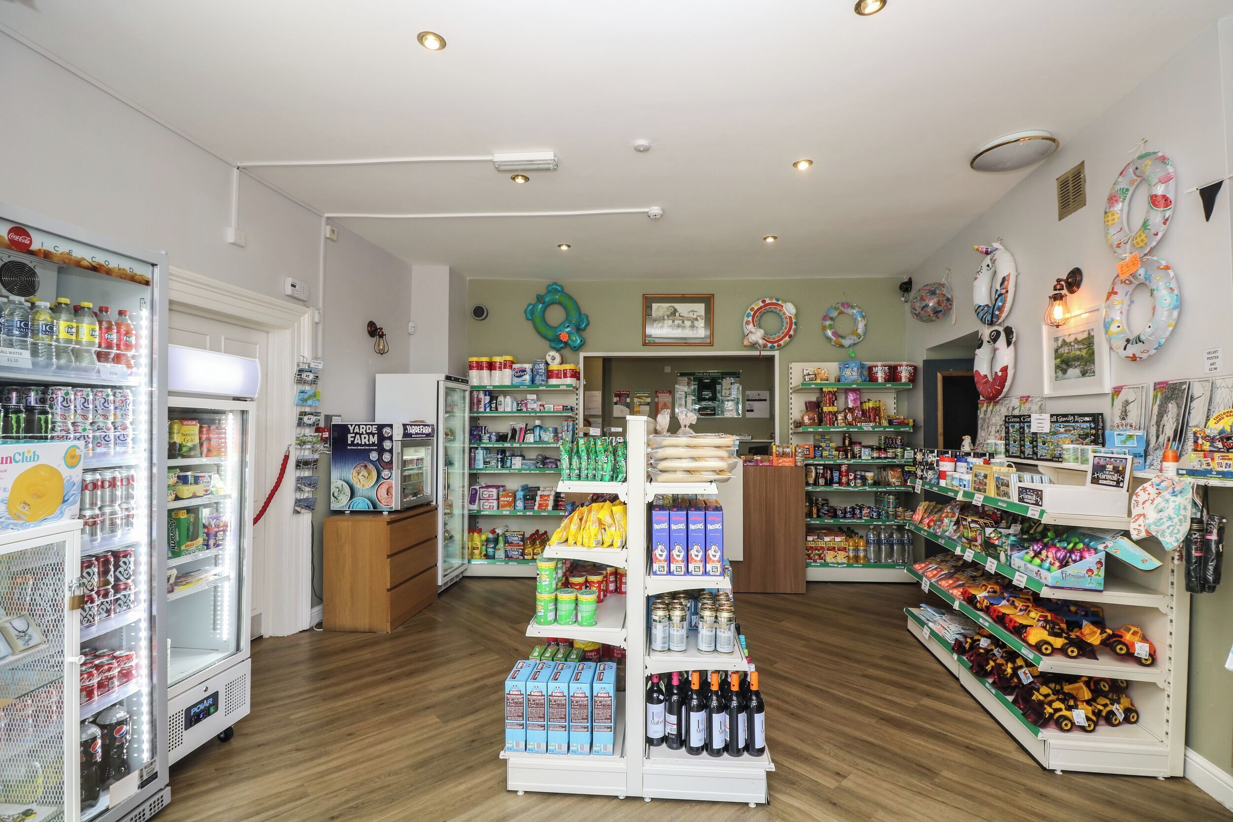 A well-lit store with shelves stocked with various products, including snacks, drinks, and toys.