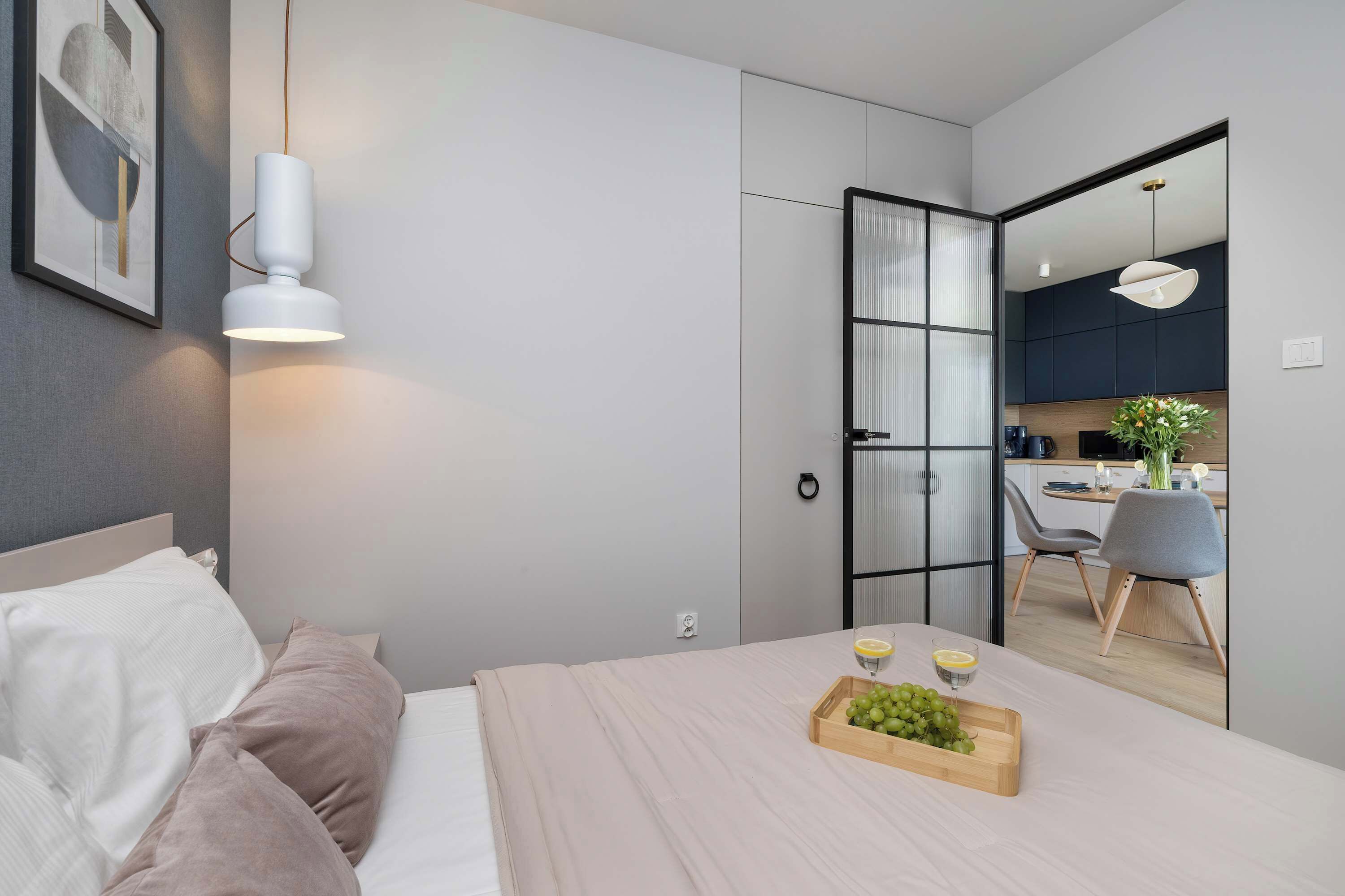 Een moderne slaapkamer met een bed, nachtkastje en een schaal fruit.