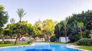 Una piscina con diseño en forma de estrella, rodeada de exuberante follaje y palmeras.
