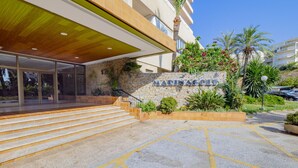 Un edificio moderno con fachada de piedra, un alero de madera y un letrero que dice "MARINAGOLF".