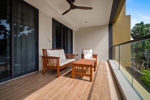 A balcony with wooden furniture, a ceiling fan, and large windows. - Reef Residences, Three-Bedroom 3302 3B Deluxe (Choeng Thale)