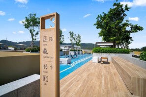 A pool area with a sign indicating facilities including a pool, playground, toilet, and lift. - Reef Residences, Three-Bedroom 3505 3B Premium (Choeng Thale)