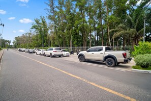 Una calle bordeada de coches aparcados y una camioneta blanca.