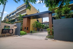 A modern building with a covered entrance, a sign for "Golden Fish Seafood," and a sign for "MAYA Beach Club Phuket."