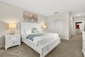Ein Schlafzimmer mit Bett, Nachttischen, Kommode und Kleiderschrank.