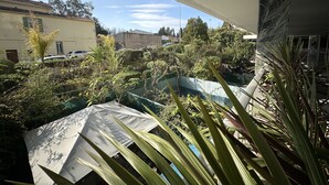 A balcony with a view of a courtyard, a pool, and surrounding buildings. - VEILLITH (Cannes)