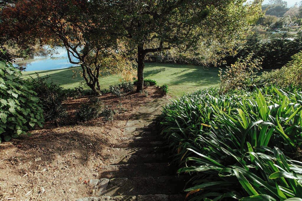A pathway leading to a golf course with a pond in the background.